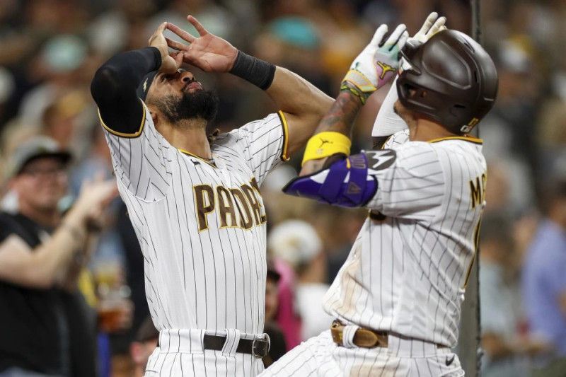 Manny Machado de los Padres de San Diego celebra con el dominicano Fernando Tatis Jr. tras pegar un jonrón solitario en la sexta entrada del juego ante los Marlins de Miami.