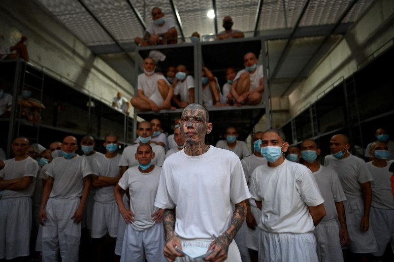 Reclusos permanecen en una celda de la megacárcel del Centro de Confinamiento Contra el Terrorismo (CECOT), donde se encuentran recluidos cientos de integrantes de las pandillas MS-13 y Calle 18.