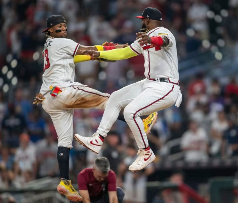 El venezolano Ronald Acuña Jr. y el dominicano Marcell Ozuna festejan la victoria de los Bravos de Atlanta sobre los Mets de Nueva York.