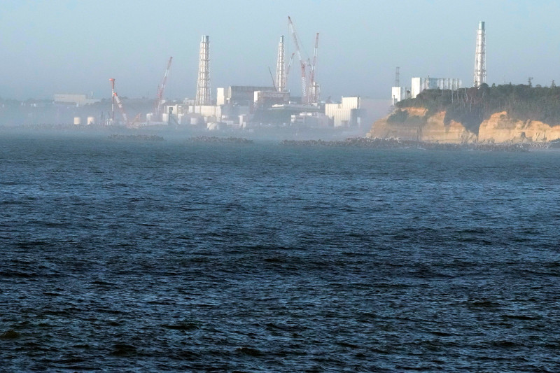 La central nuclear de Fukushima Daiichi, dañada por un enorme terremoto y un tsunami el 11 de marzo de 2011, se ve desde el cercano puerto pesquero de Ukedo en la localidad de Namie, nordeste de Japón, el jueves 24 de agosto de 2023.(AP Foto/Eugene Hoshiko)