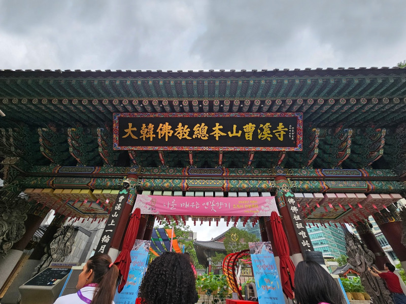 Puerta principal de ingreso al complejo. Se le conoce como “Iljumun” o puerta de un pilar, debido a que, vista de costado, parece que la sostiene un solo pilar. El letrero frente a la puerta reza “Jogyesa, sede del budismo coreano”.