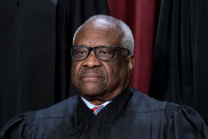 El juez asociado Clarence Thomas se une a otros miembros de la Corte Suprema para posar para un nuevo retrato grupal, en la sede de la Corte Suprema en Washington, el 7 de octubre de 2022.