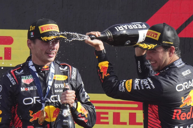 Sergio Pérez, de la escudería Red Bull, baña con champaña a su compañero Max Verstappen tras la premiación en el Gran Premio de Italia en Monza.