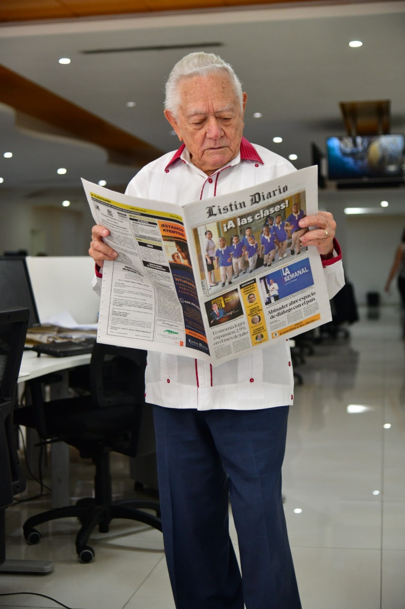 Salvador Pérez Martínez leyendo uno de los ejemplares recientes de Listín Diario, periódico en el que colaboró durante mucho tiempo reportando desde los pueblos que visitaba.