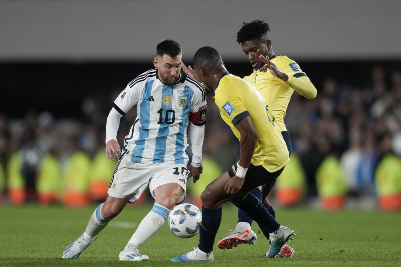 El capitán argentino Lionel Messi, a la izquierda, disputa la pelota con Carlos Gruezo, en el centro,