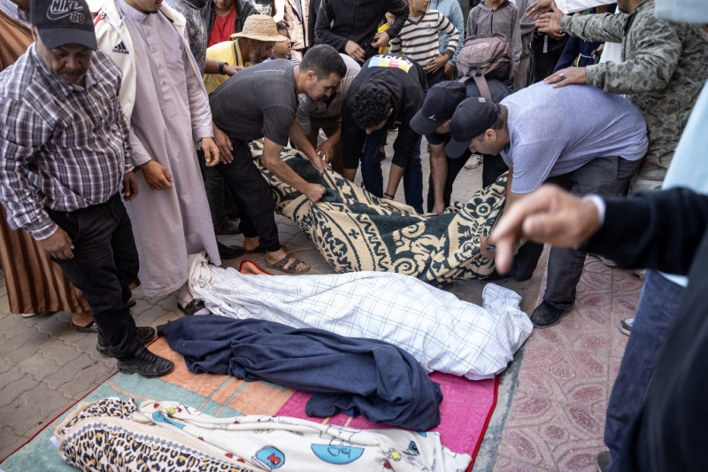 Varios hombres alinean cadáveres de las víctimas del terremoto en Moulay Brahim, provincia de Al Haouz, el 9 de septiembre de 2023