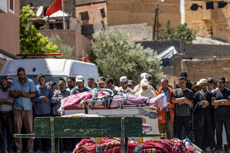 Varias personas recitan una oración ante los cadáveres de las víctimas del terremoto en Moulay Brahim, provincia de Al Haouz, el 9 de septiembre de 2023