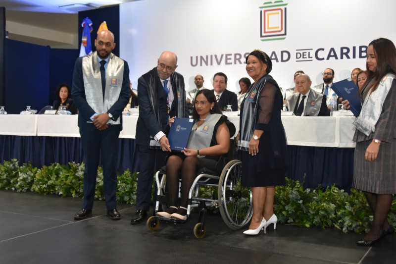 Ana María Ramírez de los Santos, paciente de esclerosis múltiple mientras recibe su título durante la cuadragésima novena graduación ordinaria de la Universidad del Caribe