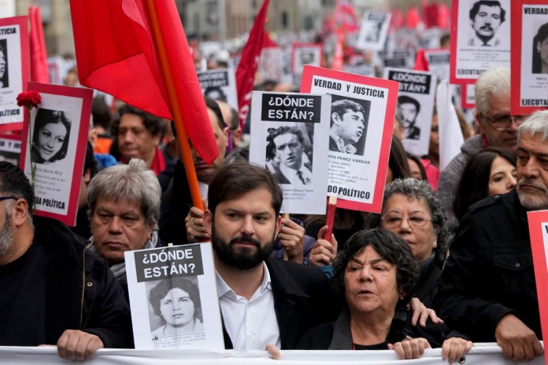 El presidente de Chile, Gabriel Boric, en el centro, participa en una manifestación que conmemora el 50 aniversario de un golpe militar liderado por el general Augusto Pinochet frente al palacio presidencial de La Moneda en Santiago, ayer.