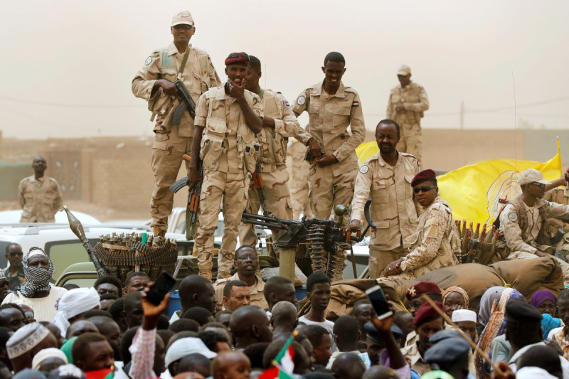Soldados del grupo paramilitar sudanés Fuerzas de Apoyo Rápido se ven de pie sobre un vehículo durante una marcha impulsada por militares en el distrito de Mayo, en el sur de Jartum, el sábado pasado.
