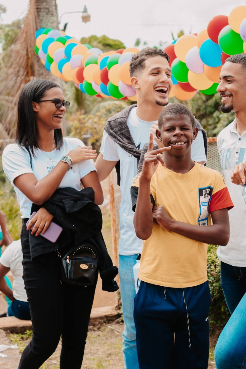 Fotografía cedida por Jóvenes con Propósito muestra joven sonriendo en el momento en que voluntarios comparten en labor en una comunidad.