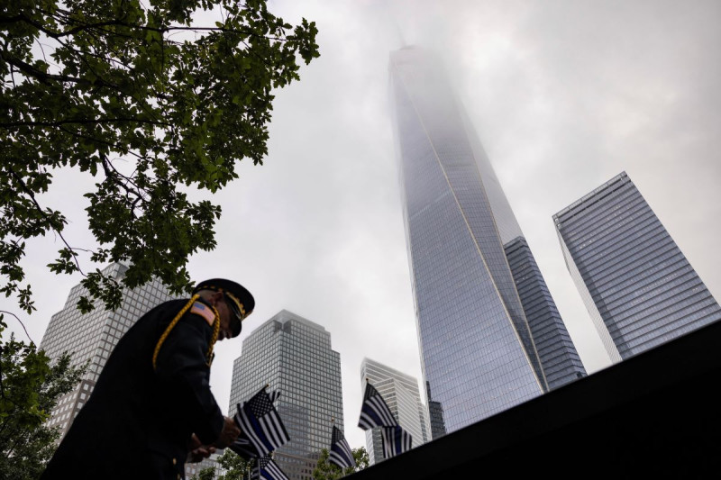 Un uniformado coloca banderas en Nueva York el 11 de septiembre de 2023, para los eventos conmemorativos de los ataques terroristas de septiembre de 2001.