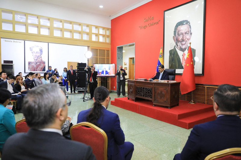 El presidente de Venezuela, Nicolás Maduro, habla durante una conferencia con la prensa internacional en Pekín ayer, con una imagen de fondo del difunto presidente de Venezuela, Hugo Chávez.
