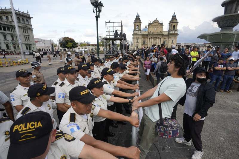 Al frente de una barricada de policías, manifestantes piden la renuncia de la fiscal general Consuelo Porras, en la Plaza de la Constitución en Ciudad de Guatemala