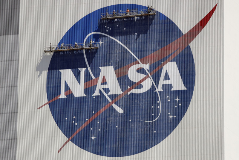 Trabajadores en andamios repintan el logo de la NASA en el Centro Espacial Kennedy, en Cabo Cañaveral, Florida, el 20 de mayo de 2020.