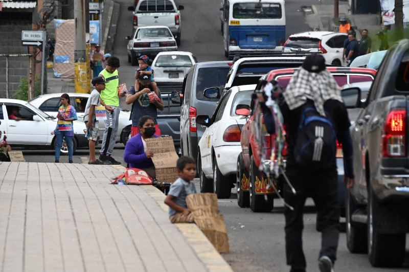Migrantes venezolanos que intentan llegar a Estados Unidos piden dinero en una calle de Tegucigalpa el 19 de septiembre de 2023.