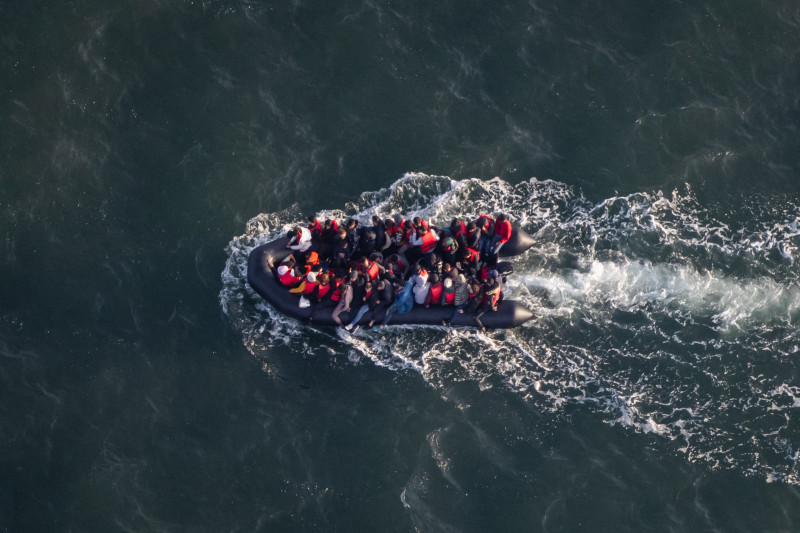 Esta fotografía aérea tomada desde un avión policial perteneciente a la Policía Francesa Aux Frontieres (PAF) muestra a inmigrantes a bordo de un bote utilizado para el contrabando mientras intentan cruzar el Canal de la Mancha al norte de Francia.