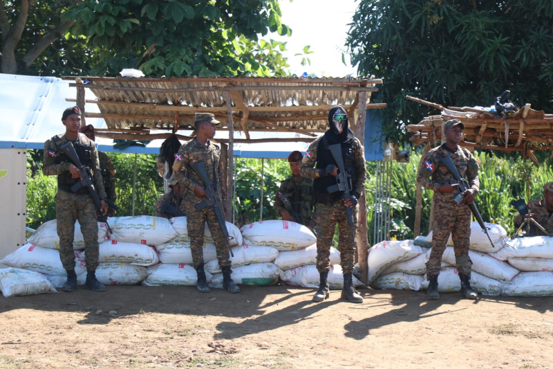 Soldados dominicanos cumplen servicios de vigilancia al lado de trincheras de arena en sacos.
