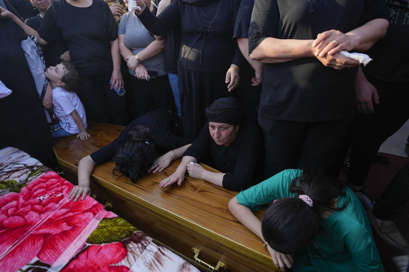 Amigos y familiares durante el funeral de las personas que murieron en un incendio durante una boda en Hamdaniya, Irak, ayer.