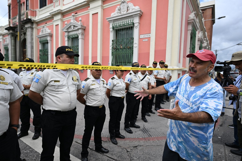 Un hombre protesta frente a agentes de policía que custodiaban la sede del Tribunal Supremo Electoral mientras fiscales del Ministerio Público realizan una redada en la Ciudad de Guatemala el 29 de septiembre de 2023. El tribunal electoral de Guatemala fue allanado el viernes por los fiscales cuestionados.