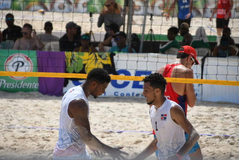 Óscar Martínez y Hayerling De Jesús se saludan durante un partido de voleibol de playa.