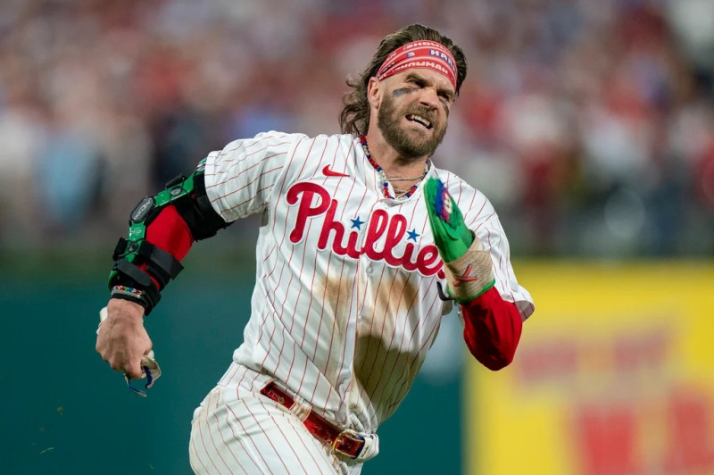 Bryce Harper, de los Filis, corre hacia el plato para anotar una carrera en el partido frente a los Marlins de Miami.