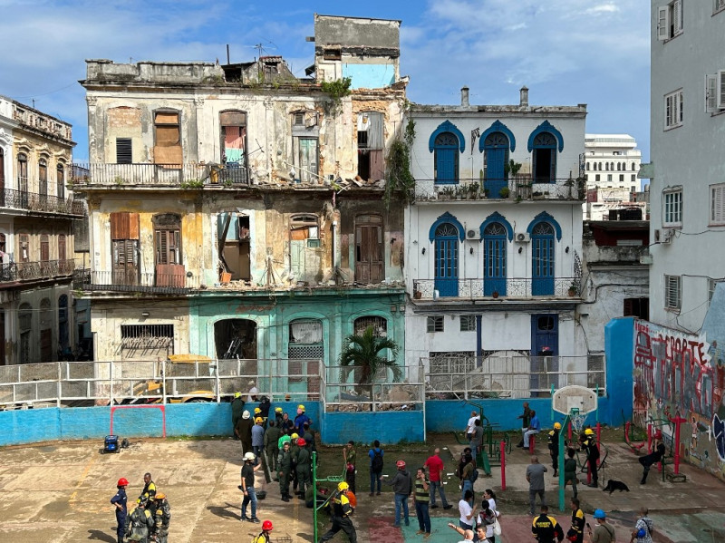 Los socorristas trabajan en un bloque de apartamentos (izq.) tras un derrumbe, en La Habana, el 4 de octubre de 2023.