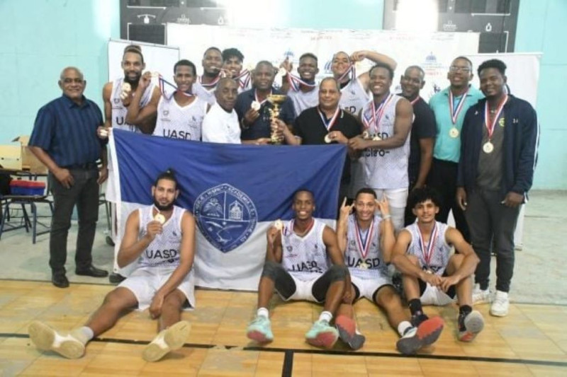 Roque García, presidente de la Comisión de Deportes Universitario, premia al equipo masculino de la UASD, ganador en la versión 2022 del torneo de baloncesto.
