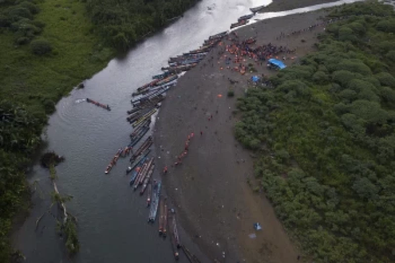 Migrantes en su ruta hacia el norte toman botes a motor para seguir el recorrido, en Bajo Chiquito, en la provincia de Darién, Panamá, tras atravesar a pie por el Tapón del Darién desde Colombia.