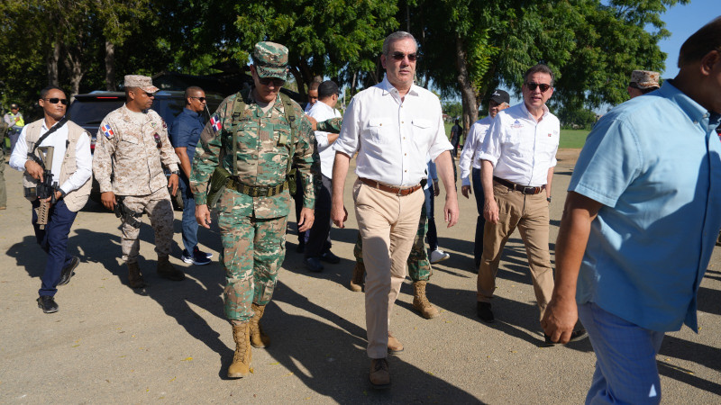 El presidente Luis Abinader, acompañado de autoridades civiles y militares, camina por una calle de Dajabón cerca de la línea divisoria con Haití.
