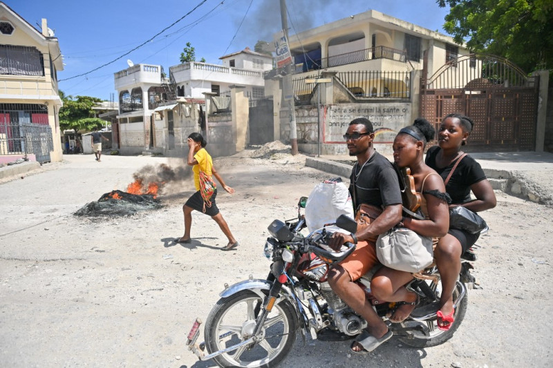 Un motociclista pasa junto a neumáticos ardiendo mientras la gente se manifiesta por el aumento del coste de la vida en Petit-Goave, Haití, el 14 de septiembre de 2023