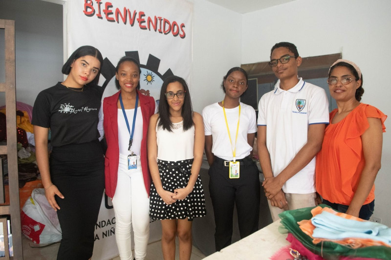 Astrid y otros jóvenes aprenden sobre el área de la moda junto a la diseñadora Marisol Henríquez.