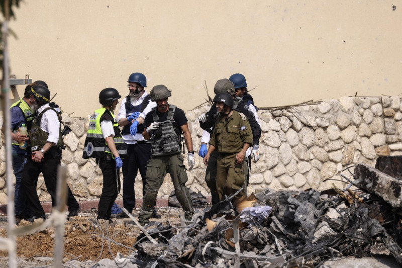 Socorristas y fuerzas de seguridad se reúnen frente a una comisaría de policía israelí en Sderot después de que resultara dañada durante los combates para desalojar a los militantes de Hamás que estaban apostados en su interior, el 8 de octubre de 2023.