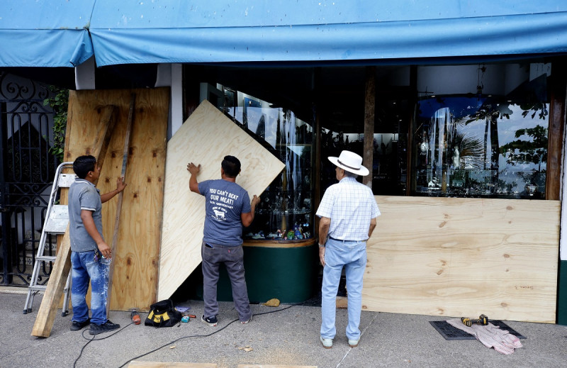 Los comerciantes toman precauciones protegiendo sus tiendas con madera en Puerto Vallarta, estado de Jalisco, México, el 10 de octubre de 2023, horas antes de que se espera que el huracán Lidia llegue a la costa del Pacífico de México.