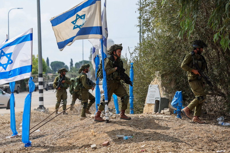 Soldados israelíes patrullan una zona en Kfar Aza, al sur de Israel, en la frontera con la Franja de Gaza.