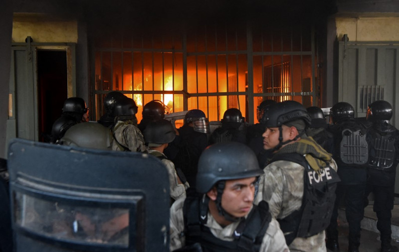 Las fuerzas de seguridad observan un incendio dentro de la prisión de Tacumbu después de que cientos de reclusos tomaran las instalaciones, en Asunción, el 10 de octubre de 2023.