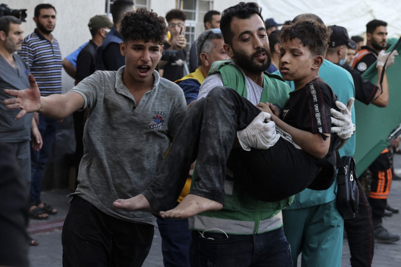 Un hombre lleva a un niño herido al hospital de al-Shifa