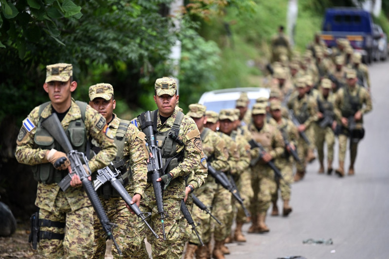 Un batallón militar patrulla una comunidad en Apopa, El Salvador, portando rifles, cascos y chalecos antibalas, unos 4,000 militares y policías rodearon partes de las ciudades salvadoreñas.