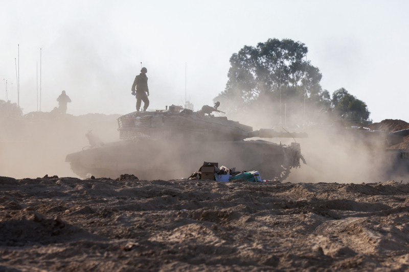 Soldados de la unidad de tanques israelíes se sitúan sobre sus vehículos blindados situados a lo largo de la frontera con Gaza.