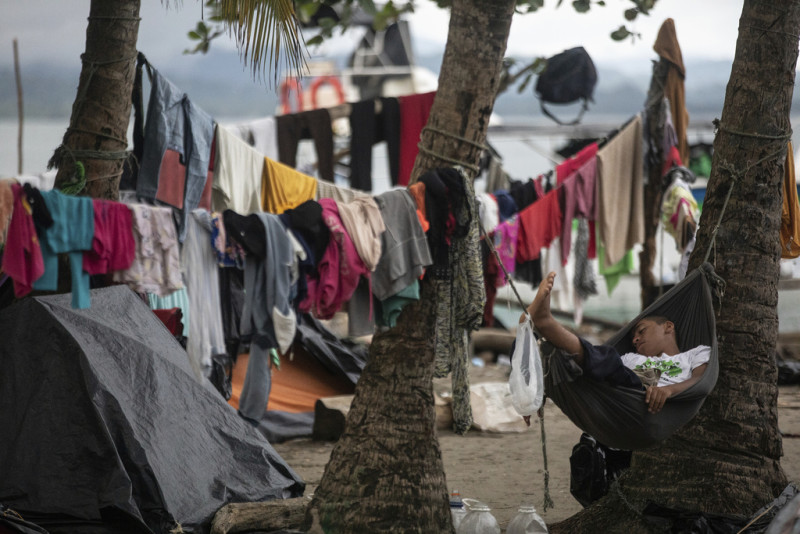 Migrantes duermen en la playa, en Necoclí, Colombia