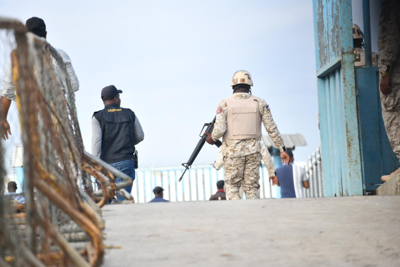 Un militar sostiene un arma mientras los portones del lado dominicano en Dajabón permanecen abiertos