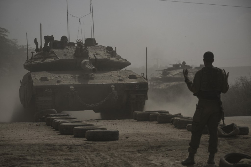 Un soldado israelí dirige un tanque de batalla Merkava mientras se despliega con otros tanques a lo largo de la frontera con la Franja de Gaza en el sur de Israel el 13 de octubre de 2023, mientras las batallas entre Israel y el movimiento palestino Hamas continúan por séptima vez consecutiva.