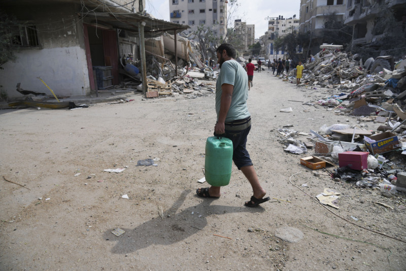 Un palestino lleva un bote de agua