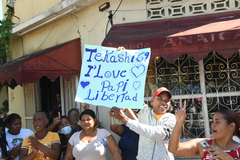 Fotografía muestra fanático del rapero Tekashi sosteniendo una pancarta con mensaje de apoyo.