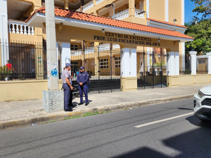 Agentes de policía en labor de vigilancia frente al Centro de Excelencia Profesor Luis Encarnación Nolasco.