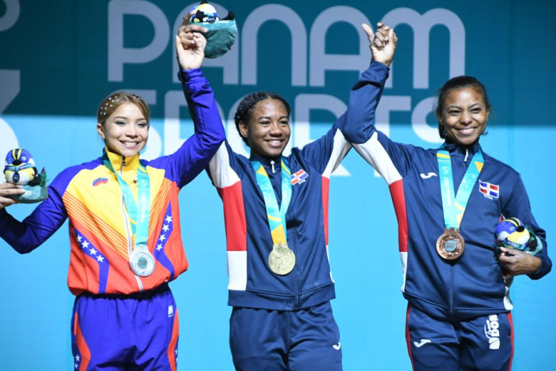 Dahiana Ortiz, oro, levanta las manos de sus contrincantes Katherin Echandía, plata, y la dominicana Beatriz Pirón, bronce.