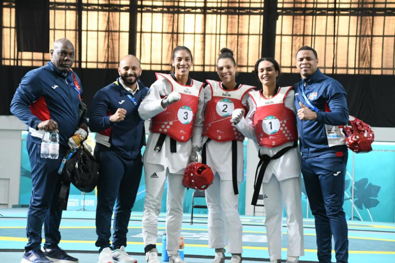Equipo femenino de taekwondo posa junto a los técnicos de esa delegación.