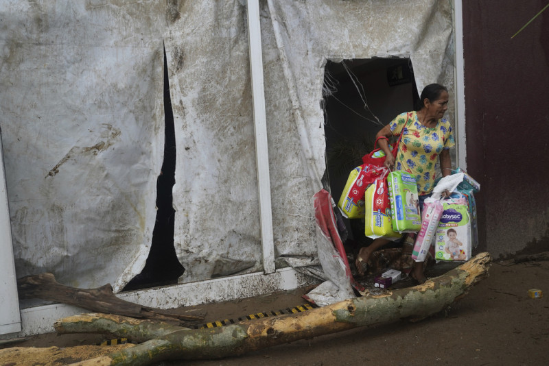 Una mujer toma pañales en un supermercado después de que el huracán Otis arrasara Acapulco