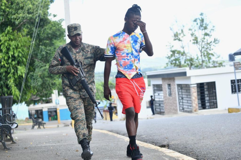Un militar dominicano conduce a un ciudadano haitiano tras su detención.