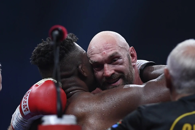 l británico Tyson Fury abraza al camerunés Francis Ngannou, luego de su combate en Riad, Arabia Saudí.